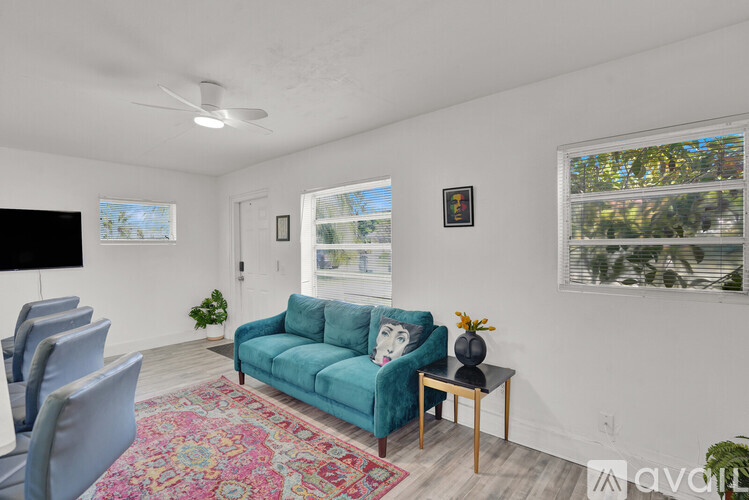 A living room with a blue couch and a rug.