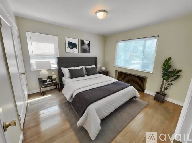 A bedroom with a large bed and a plant.