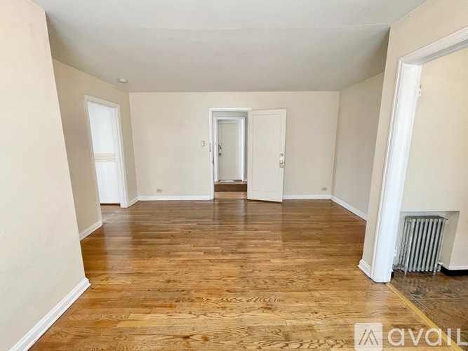 A room with wooden flooring and white walls.