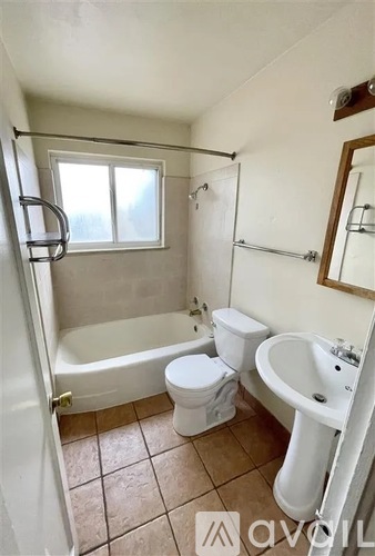 A small bathroom with a toilet, sink, and bathtub.
