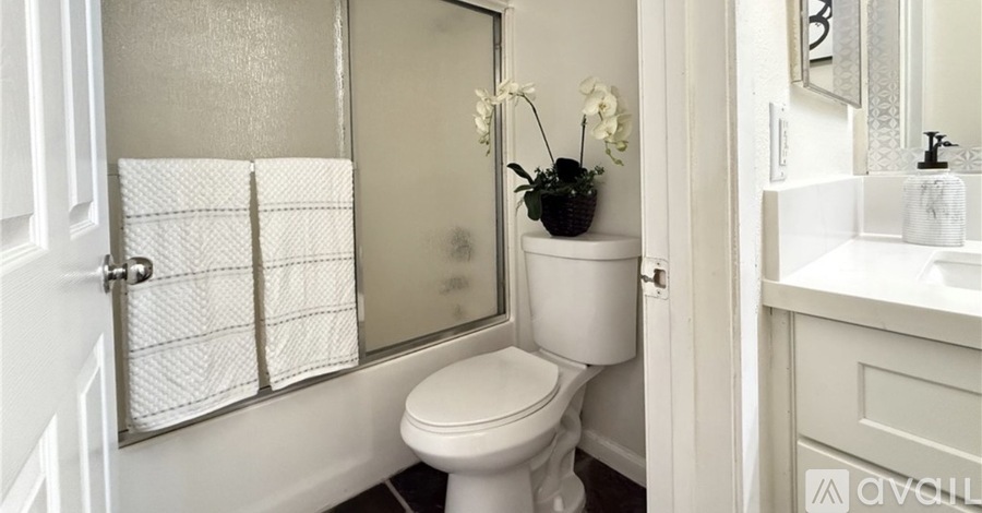 A white toilet sits next to a sink in a bathroom.
