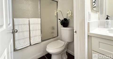 A white toilet sits next to a sink in a bathroom.
