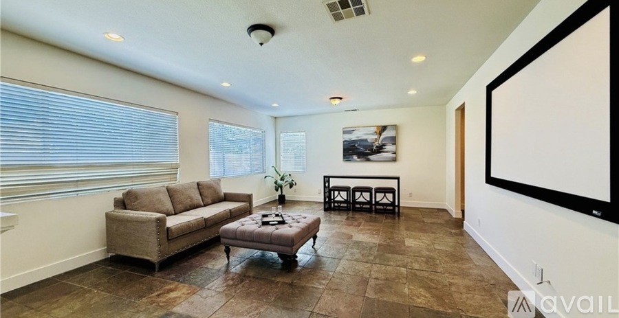 A living room with a couch, a coffee table, and a painting on the wall.