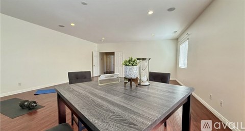 A dining room with a wooden table and chairs.