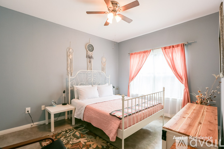 A bedroom with a white bed and a wooden table.