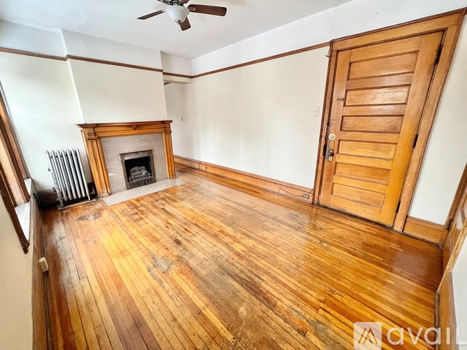 A room with a wooden floor and a fireplace.