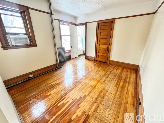 A room with wooden flooring and a window.