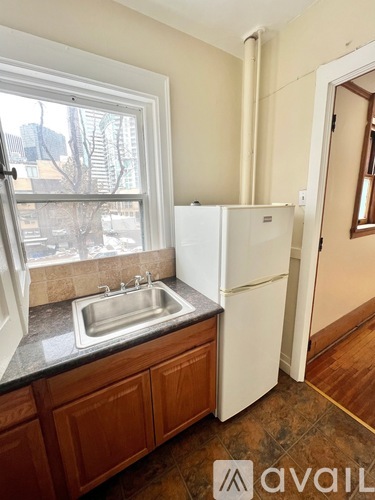 A kitchen with a sink and a refrigerator.