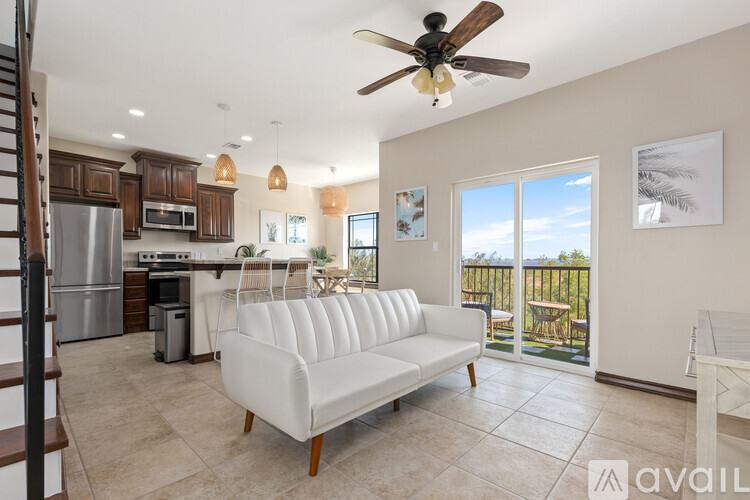 A living room with a white couch and a ceiling fan.