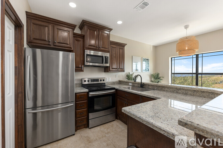A kitchen with a stainless steel refrigerator, microwave, oven, and sink.