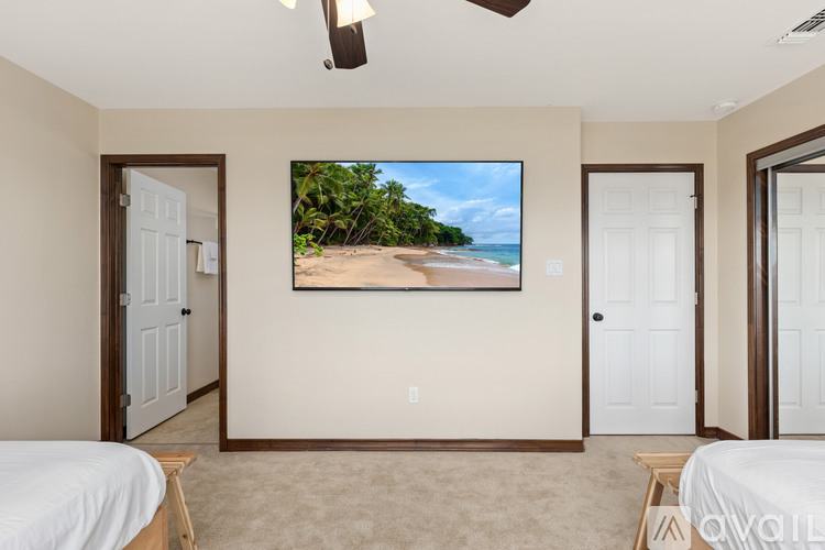 A bedroom with a large bed and a flat screen TV mounted on the wall.
