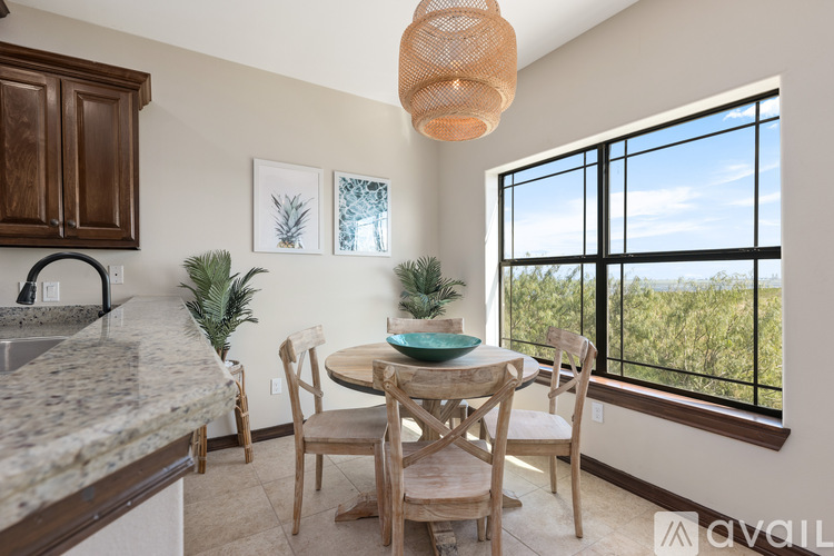A kitchen with a table and chairs and a window overlooking the ocean.