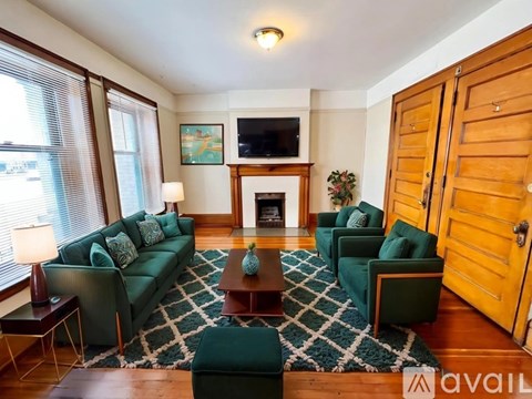 A living room with a fireplace and a television on the wall.