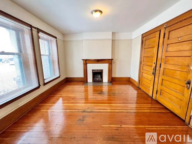 A room with wooden floors and a fireplace.