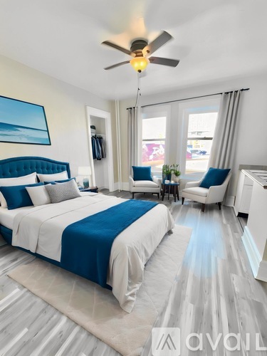 A bedroom with a large bed and a ceiling fan.