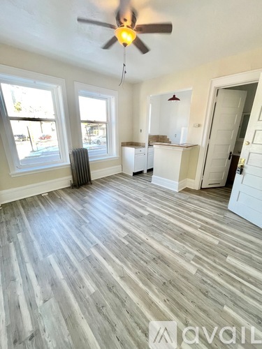 A room with a ceiling fan and wooden flooring.