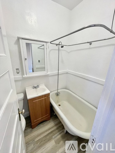 A white bathroom with a tub, sink, and mirror.