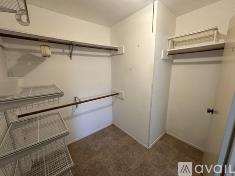 A bedroom with a bed, a desk, and a ceiling fan.