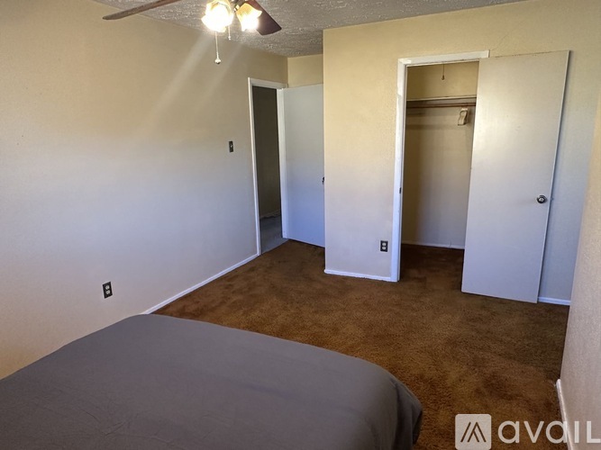 A room with a bed and a ceiling fan.