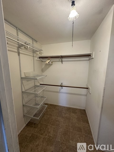 A walk-in closet with a light shining through the door.