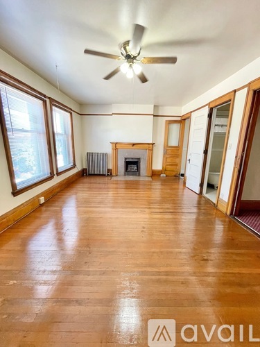 A room with wooden floors and a ceiling fan.