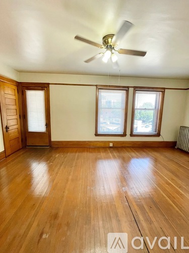 A room with wooden floors and a ceiling fan.