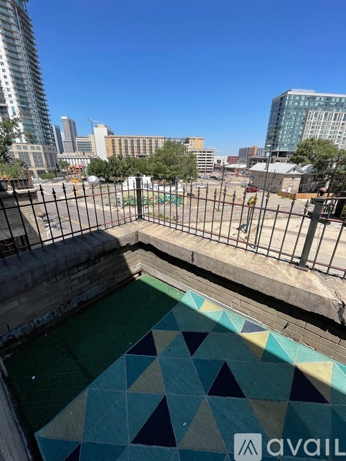 A pool with a geometric patterned bottom is surrounded by a metal fence.