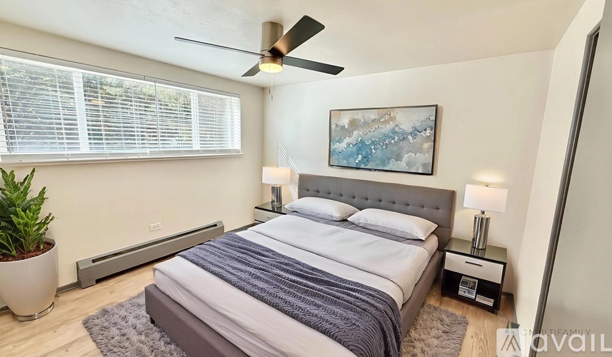 A bedroom with a bed, nightstand, and a ceiling fan.