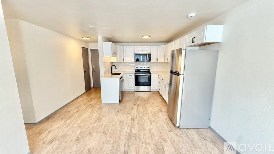 A kitchen with white appliances and wooden floors.