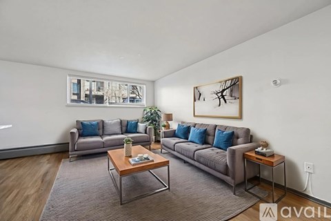 A living room with a grey sofa, a wooden coffee table, and a painting on the wall.