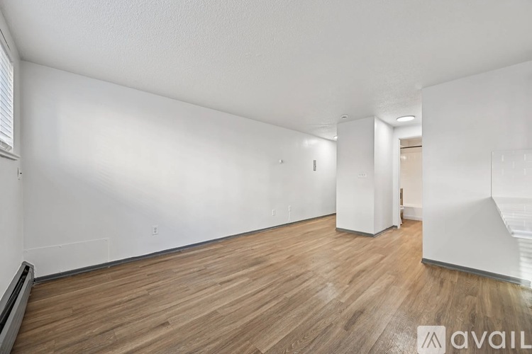 A room with wooden flooring and white walls.
