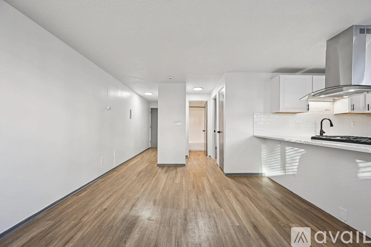 A long hallway with wood floors and white walls.
