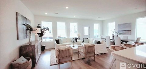 A living room with a white sofa set and a wooden cabinet.