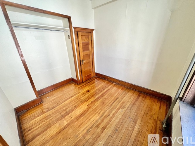 A wooden floor in a room with a door and a window.