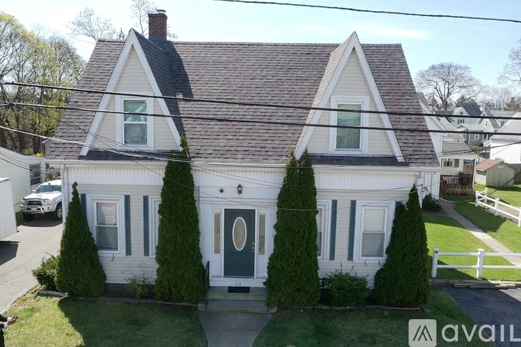 A house with a triangular roof and a green door is for sale.