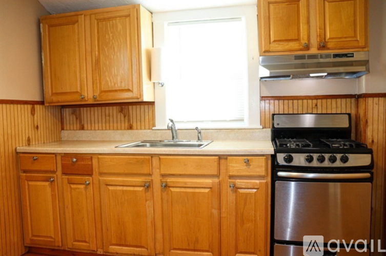 A kitchen with wooden cabinets and a stainless steel stove.