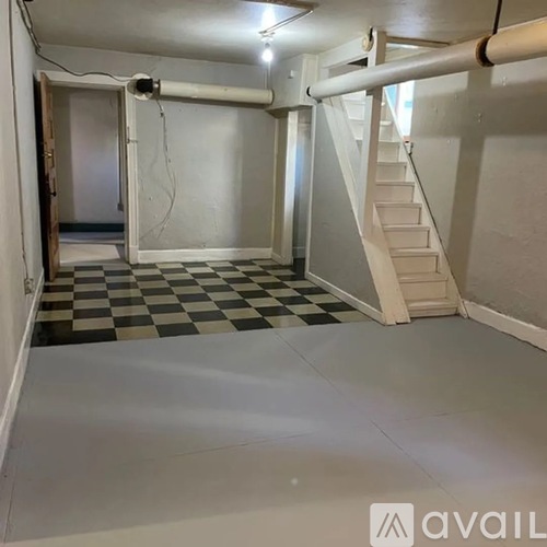 A black and white checkered floor in a room with a staircase.