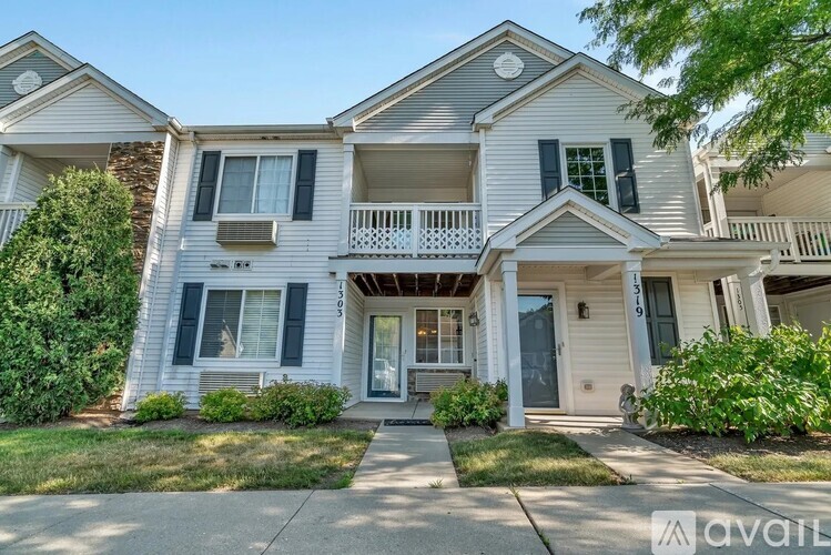 A two-story house with a front porch and a balcony.