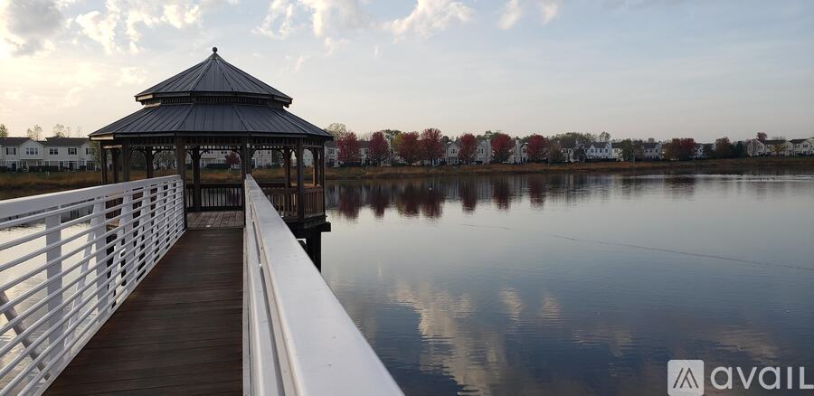 A gazebo sits on a dock over a calm body of water.