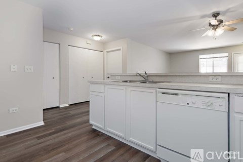 A kitchen with white cabinets and a wooden floor.