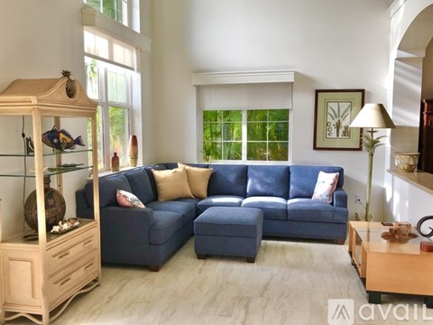 A living room with a blue sofa and a wooden cabinet.