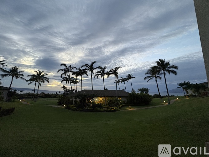 A golf course with palm trees and a clubhouse in the background.