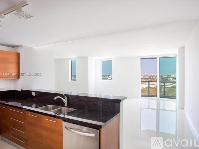 A kitchen with a sink, a window and a counter.