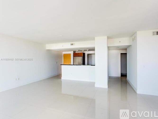 A large empty room with a doorway leading to another room.