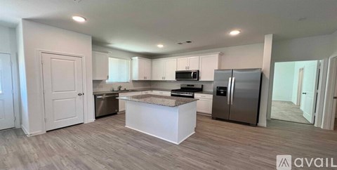 A kitchen with a white island and stainless steel appliances.