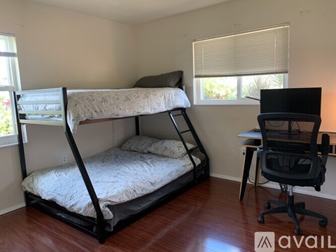 A bedroom with a bunk bed and a desk with a chair.