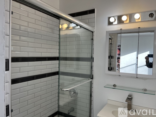A bathroom with a glass shower door and a white toilet.