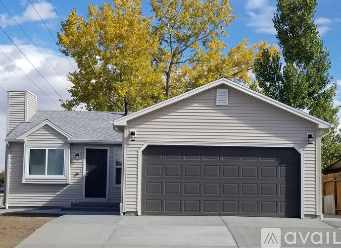 A house with a grey garage door is for sale.