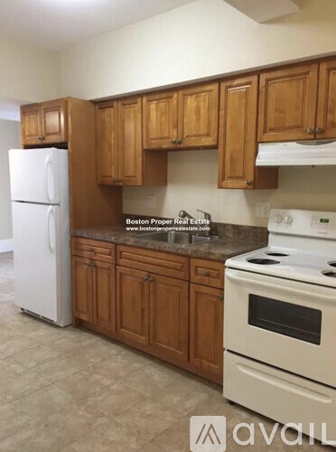 A kitchen with wooden cabinets and a white refrigerator.