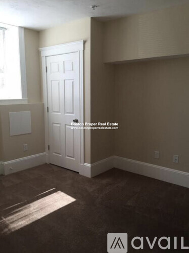 A room with a door and a window with a mat on the floor.